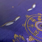 Macro detail of hand-painted gold linework on Mahavairocana Buddha Eyes purple canvas.