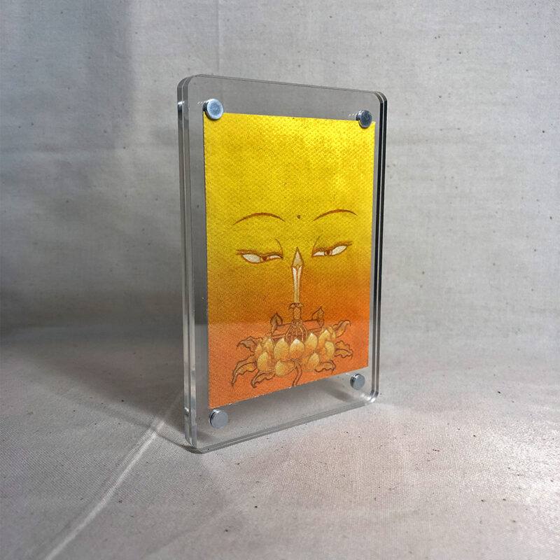 Side-angle view of freestanding clear acrylic block displaying Manjushri line art.