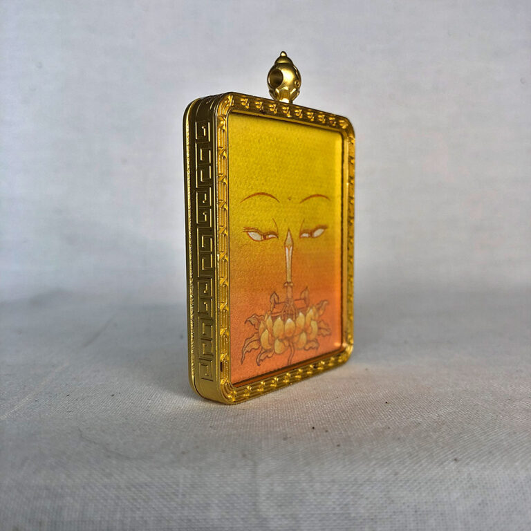 Three-quarter side angle of Manjushri Buddha Eyes gold brass Gau box pendant.