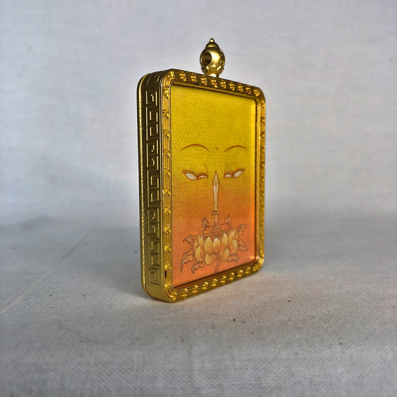 Three-quarter side angle of Manjushri Buddha Eyes gold brass Gau box pendant.