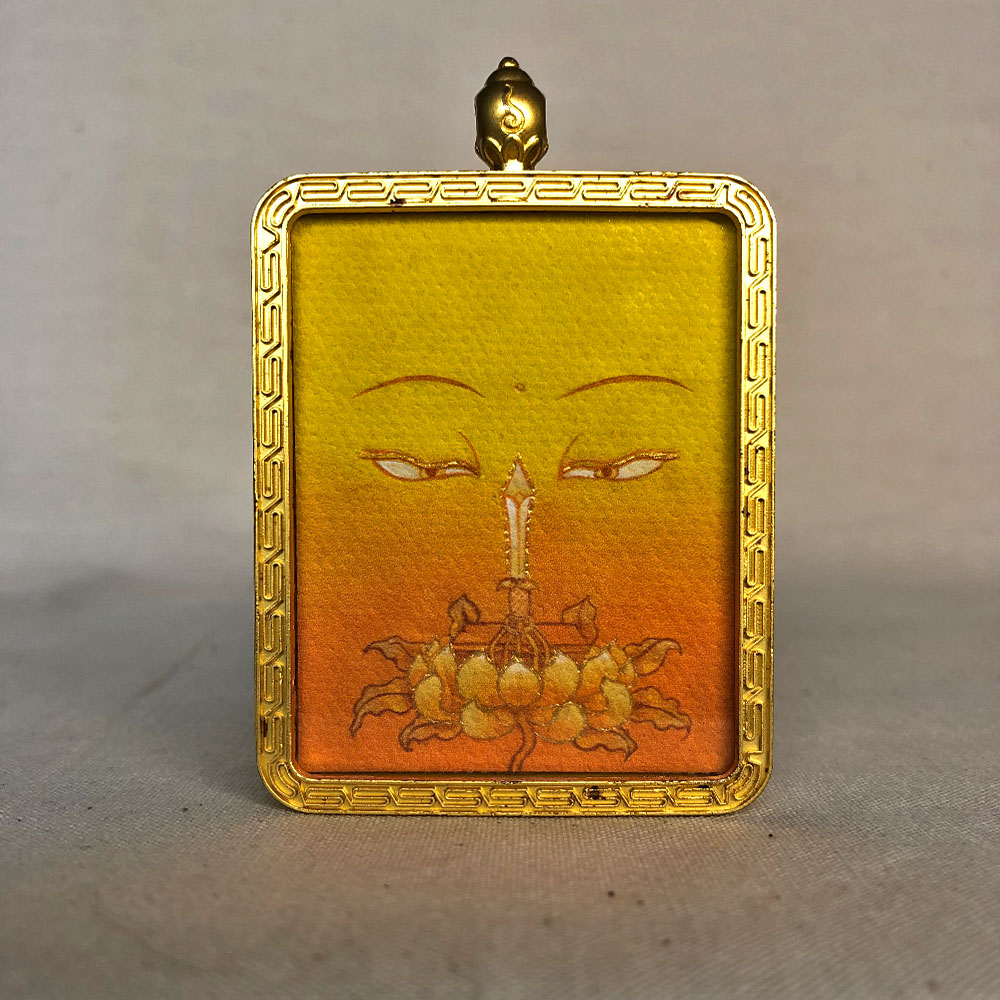manjushri-buddha-eyes-yellow-color-meditation-gau-box Frontal view of Manjushri Buddha Eyes pendant for Solar Plexus Chakra color meditation.