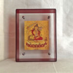 Front view of golden Manjushri Bodhisattva Thangka print in a red floating acrylic frame.