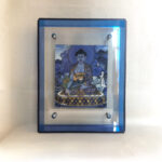 Front view of Medicine Buddha Thangka print in a blue floating translucent acrylic frame.