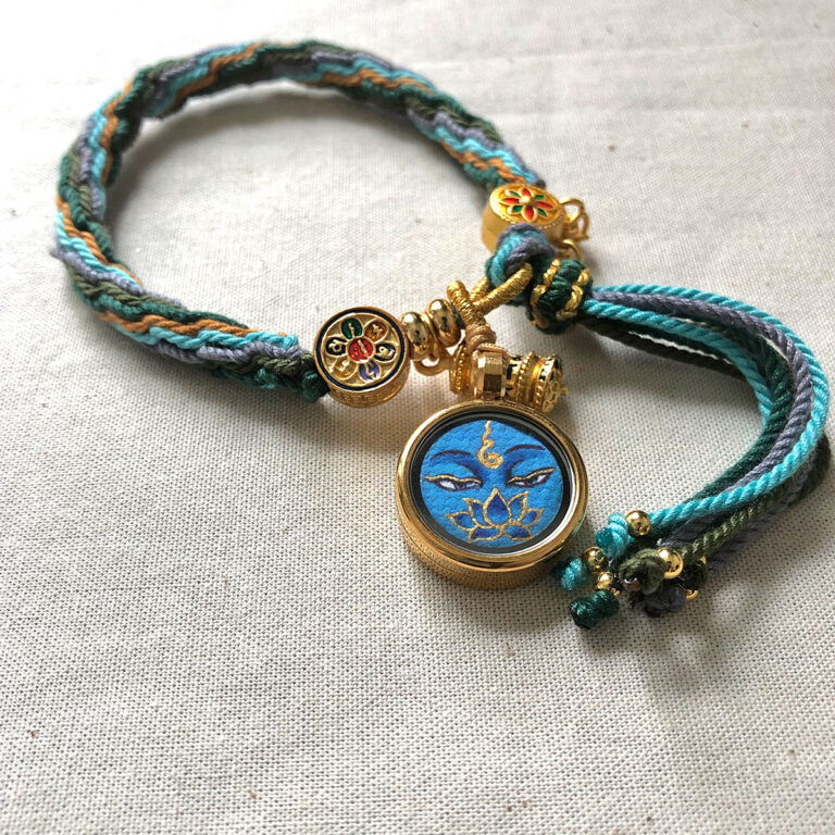 Flatlay layout of the blue Medicine Buddha Eyes braided cord bracelet for mindfulness.