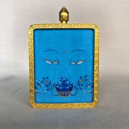 Frontal view of Medicine Buddha Eyes pendant for Throat Chakra color meditation.