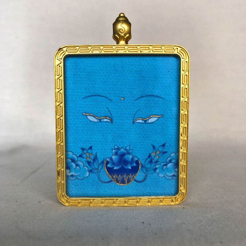 Frontal view of Medicine Buddha Eyes pendant for Throat Chakra color meditation.