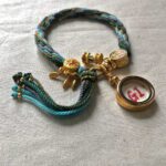 Backside view of the blue Medicine Buddha charm bracelet displaying the authentic brand emblem.