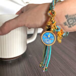 Blue Medicine Buddha Eyes charm bracelet worn on wrist for daily calm.