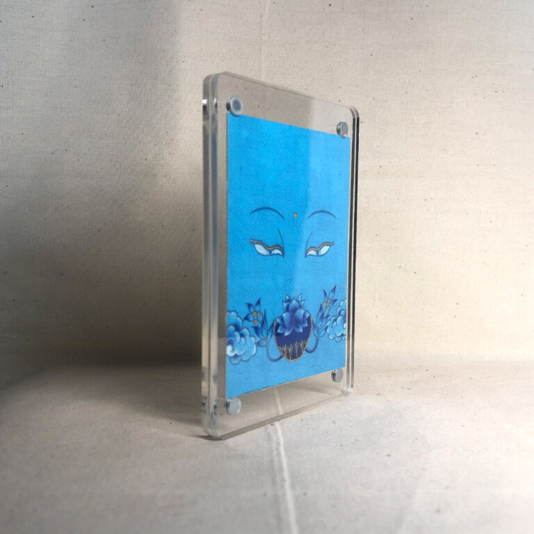 Side-angle view of freestanding clear acrylic block displaying Medicine Buddha line art.