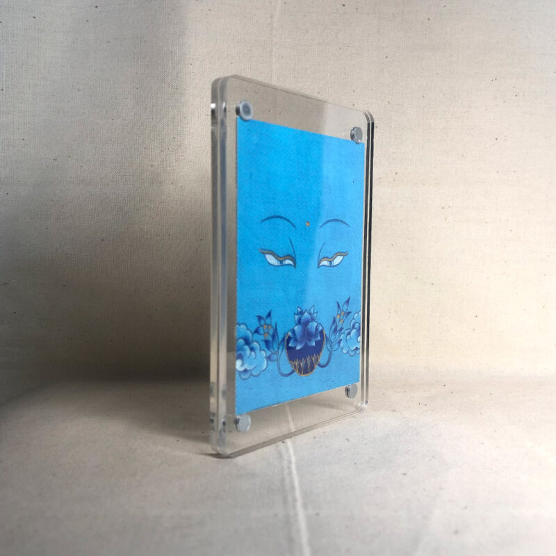 Side-angle view of freestanding clear acrylic block displaying Medicine Buddha line art.