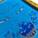Macro detail of hand-painted gold linework on Medicine Buddha Eyes blue fine art canvas.