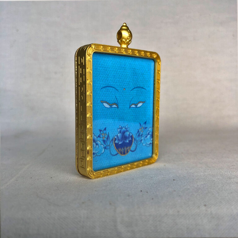 Three-quarter side angle of Medicine Buddha Eyes gold brass Gau box pendant.