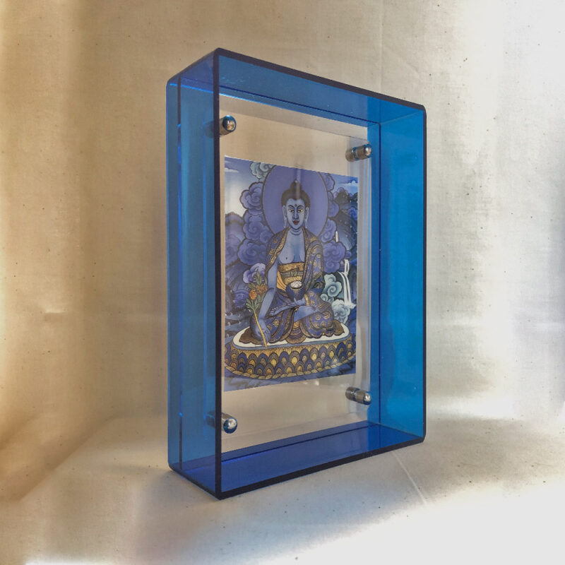 Side perspective of Medicine Buddha Thangka print inside a blue translucent acrylic display frame.