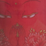 Close-up of original hand-painted gold linework and wisdom Buddha eyes on orange canvas.