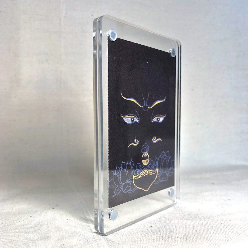 Side-angle view of freestanding clear acrylic block displaying Padmasambhava line art.