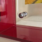 Close-up of magnetic corner screw on deep red translucent acrylic display block.