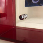 Close-up of corner magnetic screw on red translucent acrylic display block.
