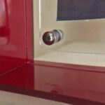 Close-up of magnetic corner screw on deep red translucent acrylic display block.
