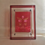 Front view of red Jambhala Buddha Eyes print in a red floating translucent acrylic frame.