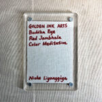 Backside of clear acrylic frame displaying artist signature card and magnetic corner screws.