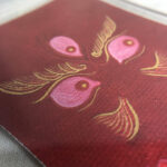 Macro detail of hand-painted gold linework on Red Jambhala Buddha Eyes red canvas.