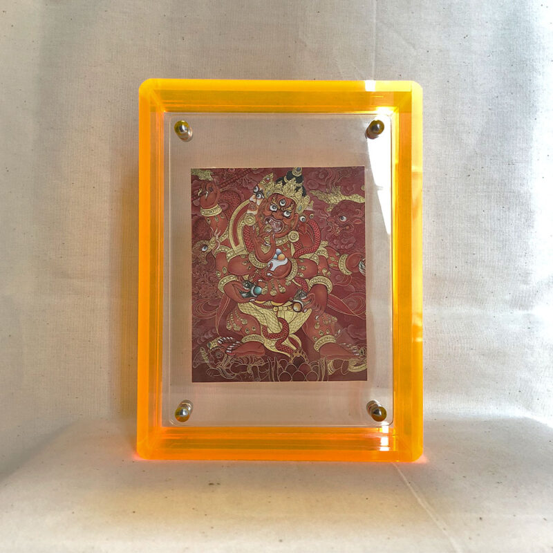 Front view of Red Jambhala Thangka print in a yellow floating translucent acrylic frame.