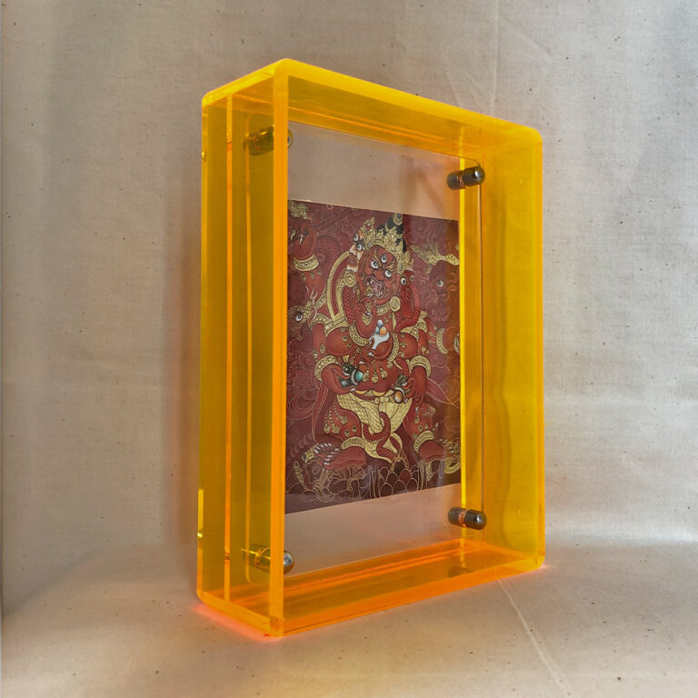 Side perspective of Red Jambhala Thangka print inside a yellow acrylic display frame.