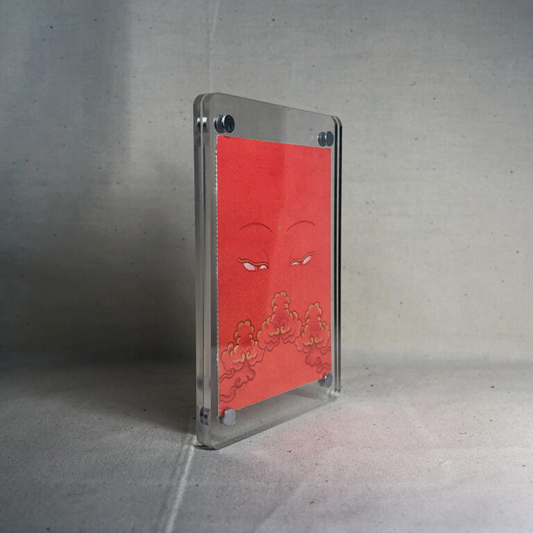Side-angle view of freestanding clear acrylic block displaying Shakyamuni Buddha line art.