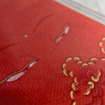 Macro detail of hand-painted gold linework on Shakyamuni Buddha Eyes orange canvas.