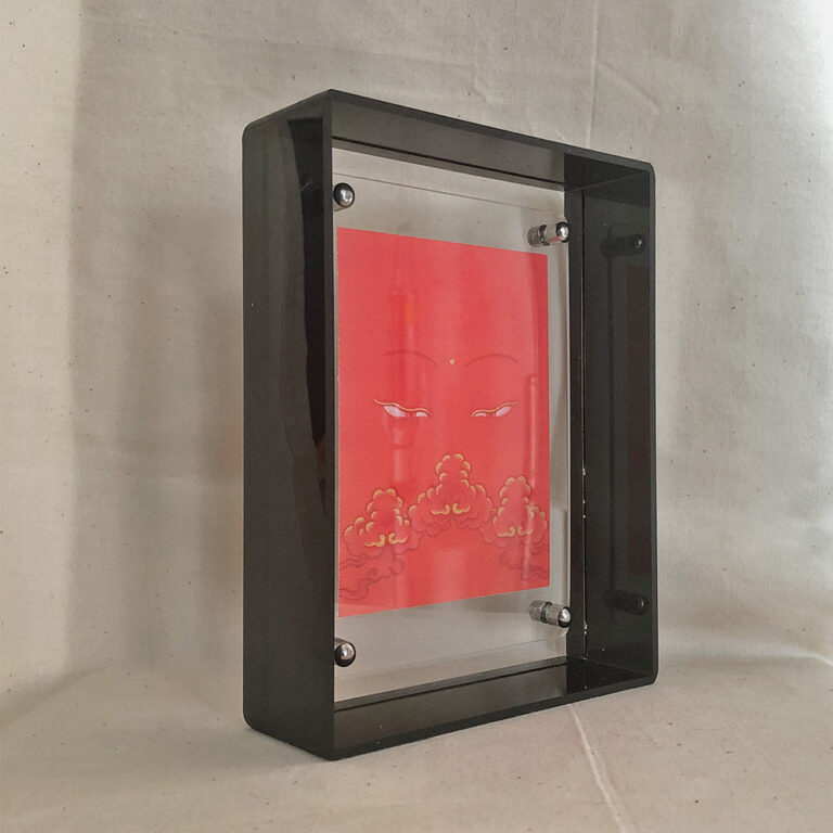 Side perspective of Shakyamuni Buddha Eyes art inside a black translucent acrylic frame.