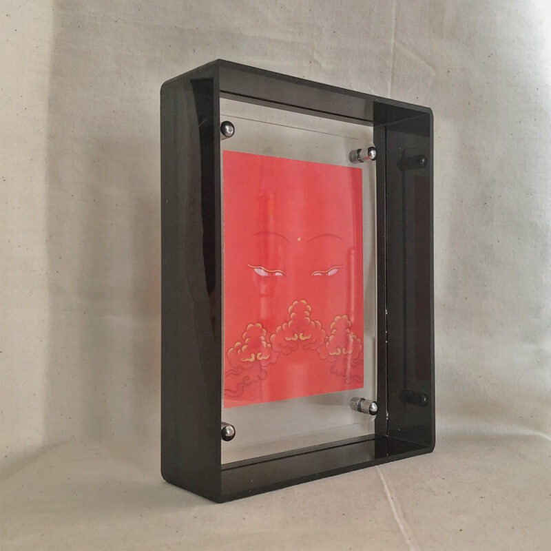 Side perspective of Shakyamuni Buddha Eyes art inside a black translucent acrylic frame.