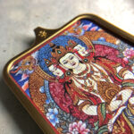 Close-up of Vairocana Buddha pendant in gold Gau box for zodiac guardian meditation.