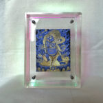 Front view of blue Vajrapani Thangka print in an iridescent rainbow floating acrylic frame.