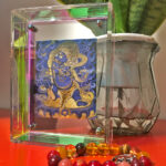 Blue Vajrapani Thangka iridescent acrylic art block styled next to indoor plant on a desk.