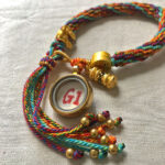 Backside view of the purple Vajrasattva charm bracelet displaying the authentic brand emblem.