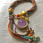 Flatlay layout of the purple Vajrasattva Buddha Eyes braided cord bracelet for meditation.