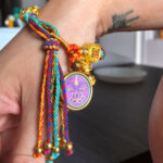 Purple Vajrasattva Buddha Eyes charm bracelet worn on wrist for daily mindfulness.
