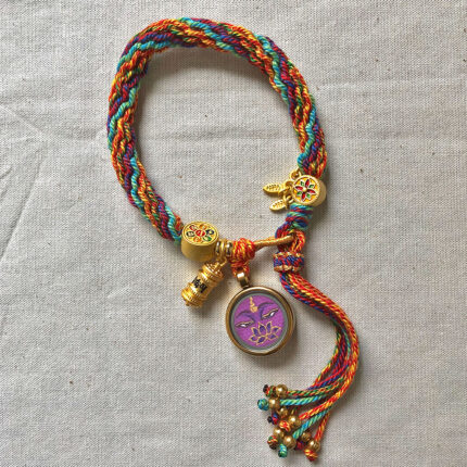 Vertical layout of the purple Vajrasattva Buddha Eyes charm bracelet with woven cord.