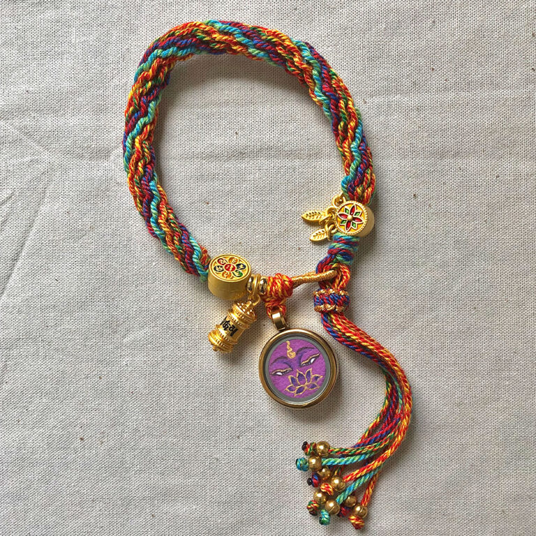 Vertical layout of the purple Vajrasattva Buddha Eyes charm bracelet with woven cord.