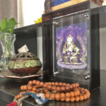Purple Vajrasattva Thangka black acrylic art block styled next to prayer beads on a desk.
