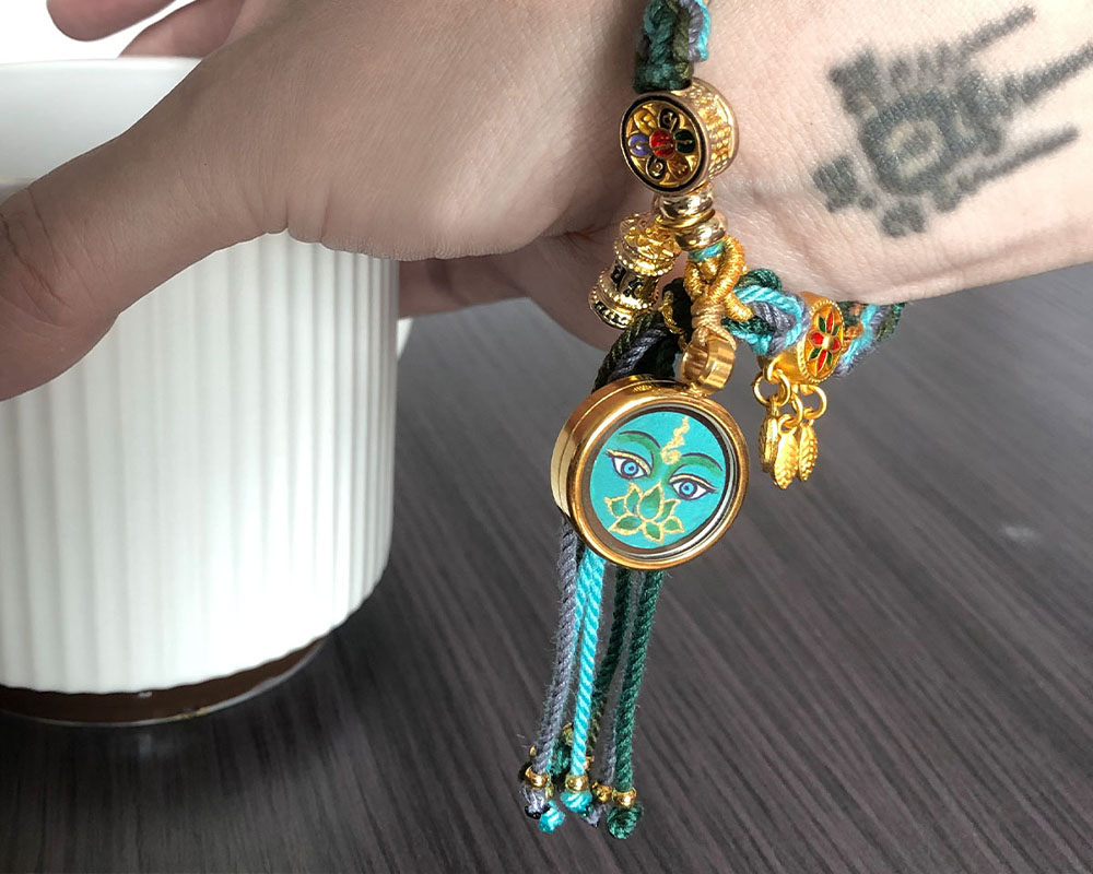 A person wearing the Buddha Eye meditation bracelet on their wrist during daily activities