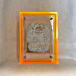 Front view of White Jambhala Thangka print in a yellow floating translucent acrylic frame.