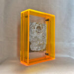 Side perspective of White Jambhala Thangka print inside a yellow acrylic display frame.
