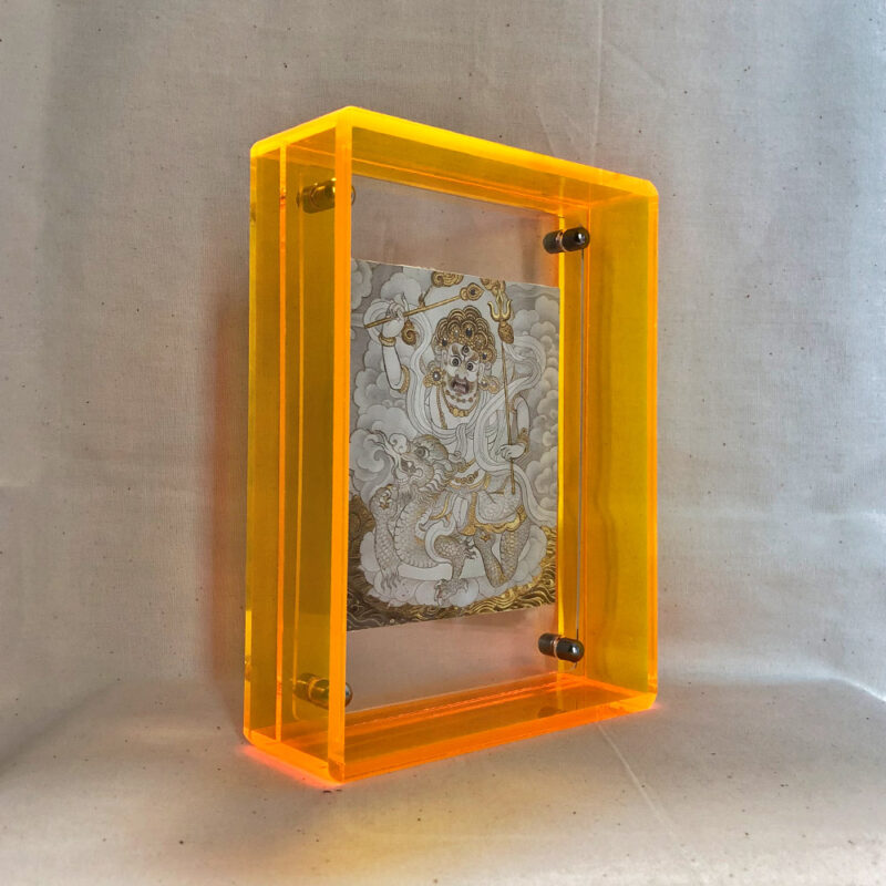 Side perspective of White Jambhala Thangka print inside a yellow acrylic display frame.