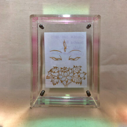 Front view of white Tara Buddha Eyes print in an iridescent floating translucent acrylic frame.
