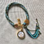 Flatlay layout of the White Tara Buddha Eyes braided cord bracelet.
