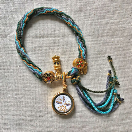 Flatlay layout of the White Tara Buddha Eyes braided cord bracelet.
