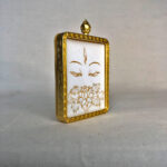 Three-quarter side angle of White Tara Buddha Eyes gold brass Gau box pendant.