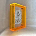 Side perspective of White Tara Thangka print inside a yellow translucent acrylic display frame.