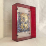 Side view of Yamantaka Thangka art print inside a thick red clear acrylic desk display frame.